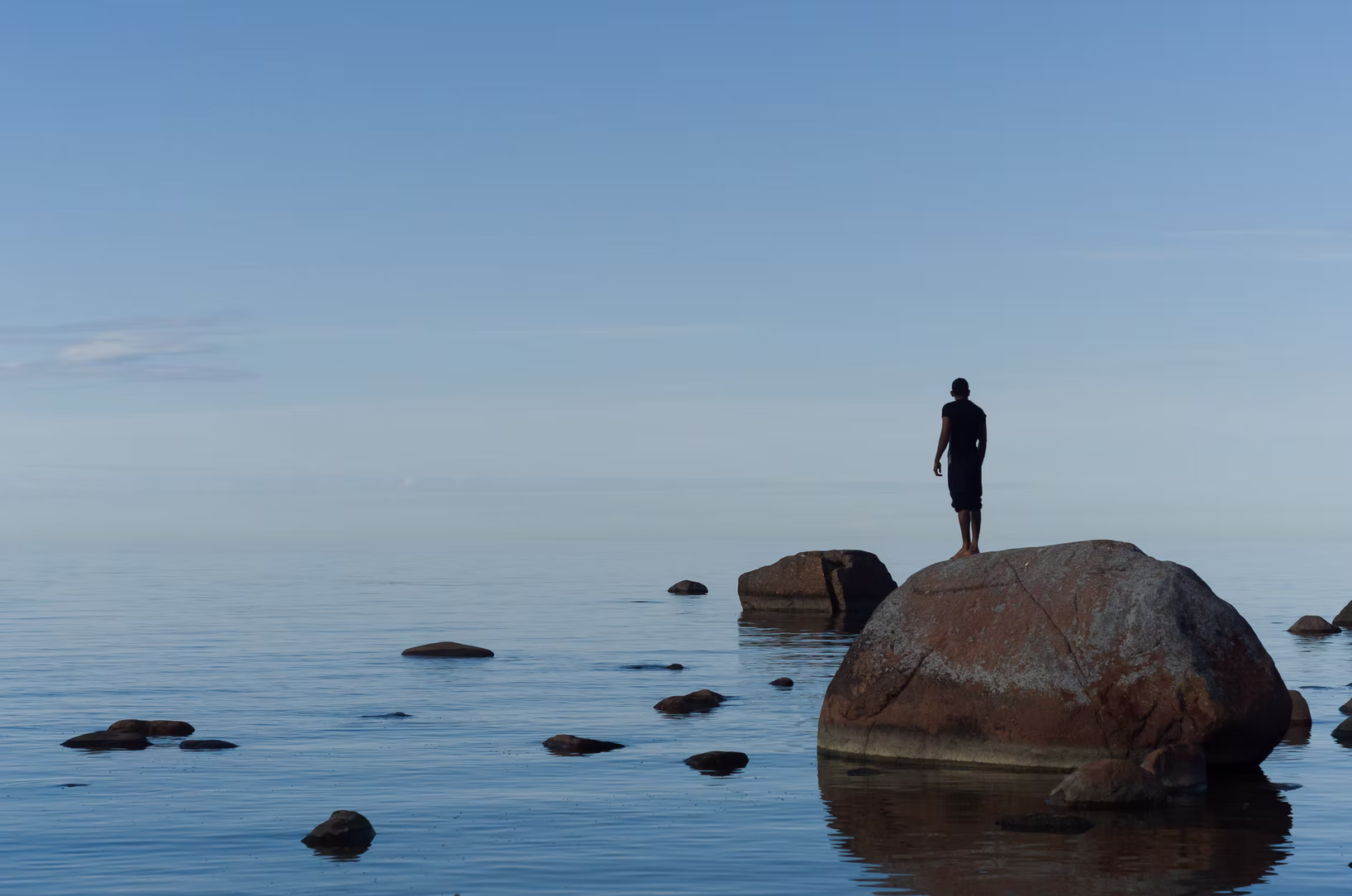Someone standing on a rock, contemplating